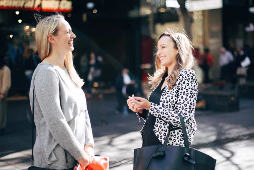 Hayley Cooper laughs with a client on the street.