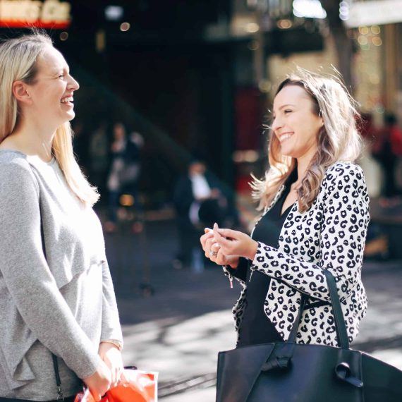 Hayley Cooper laughs with a client on the street.