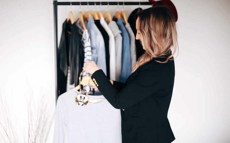 Hayley Cooper hangs clothing on a rack.