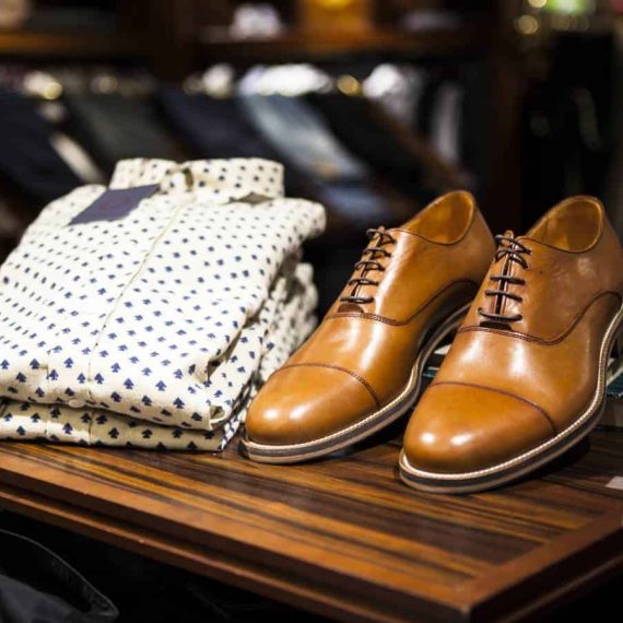 Men's folded shirt and shoes are on display.